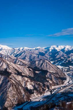 Japonya 'da kış mevsiminde mavi gökyüzü arka planına karşı beyaz kar ve güzel manzara
