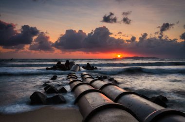 Güneş doğarken güzel manzara tropikal sahilde altın gökyüzüne ve bulutlu balkon alanına karşı