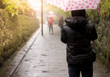 Yağmurlu bir günde yürüyen yürüyüş botları ve kot pantolon yalnız adam