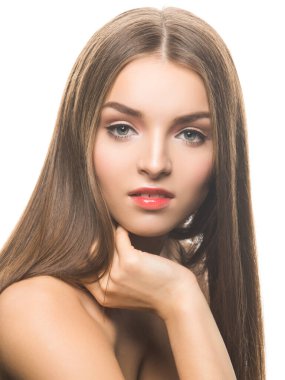 Profesyonel makyajlı genç ve çekici bir kadın model kameraya bakıyor ve beyaz bir yüze dokunuyor..