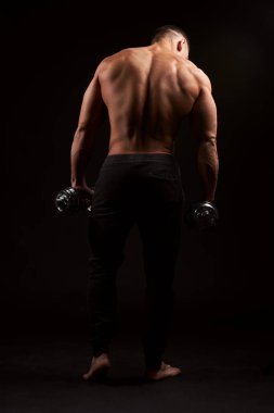 Siyah arka plandaki kaslı adama karşı. Stüdyo çekimi