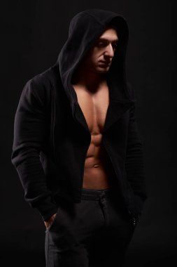Siyah kapüşonlu bir vücut geliştirici. Stüdyo çekimi. İzole edilmiş