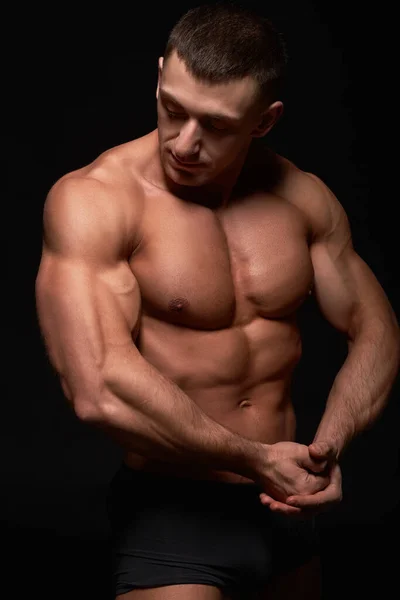 黒を背景にした筋肉のボディビルダーの肖像 — ストック写真