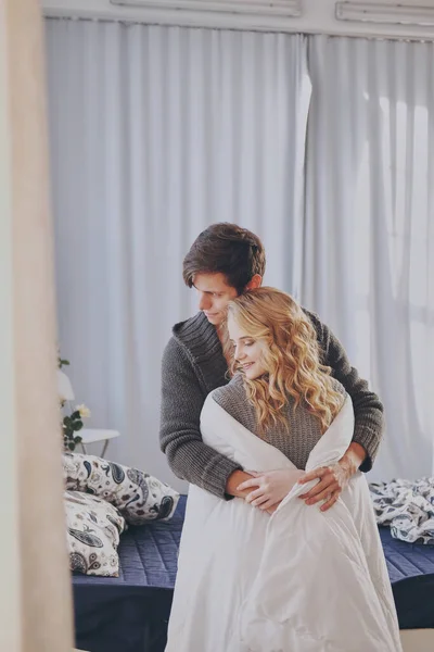 Attractive man and woman in the bedroom together cuddling cute — Stock Photo, Image