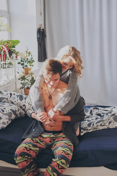 Çekici bir erkek ve kadın yatak odasında birbirlerine sarılıyorlar. — Stok fotoğraf