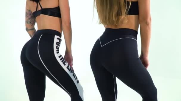 Two Sexy Women In The Studio Posing For The Camera In Yoga Pants Stock Footage Two Sexy Women In The Studio Posing For The Camera In Yoga Pants Stock Footage