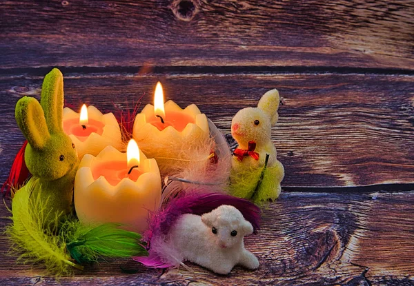 浪漫的复活节组合与燃烧的蜡烛 兔子和复活节羊肉在五颜六色的羽毛在复古风格 — 图库照片