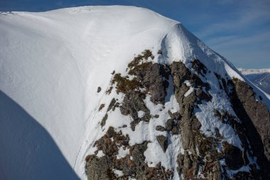 Karla kaplı kaya. Karda taşlar.