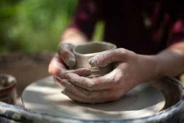 Potter işte. Eller kilden heykel yapar. Tabak oluşturma.