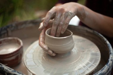 Potter işte. Eller kilden heykel yapar. Tabak oluşturma.