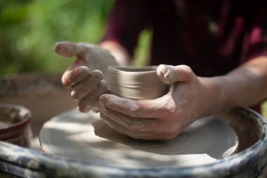Potter işte. Eller kilden heykel yapar. Tabak oluşturma.