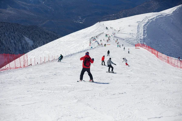 Karlı bir yamaçta snowboardcular. Dağ kayak merkezi. 