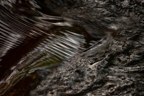 A superfície da água. Pequenas ondas em um fluxo de água . — Fotografia de Stock