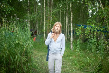 Büyük sakallı bir adam. Adam doğada seyahat ediyor.. 