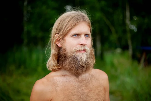 A guy with a big beard is resting in the forest. — Stock Photo, Image