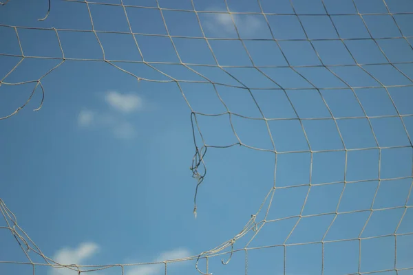 Maille déchirée contre le ciel bleu. — Photo