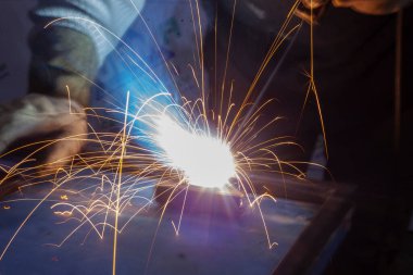 Metal kaynaklama. Sıcak metalden kıvılcımlar uçuşuyor.