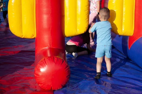 As crianças brincam em uma área infantil inflável. — Fotografia de Stock