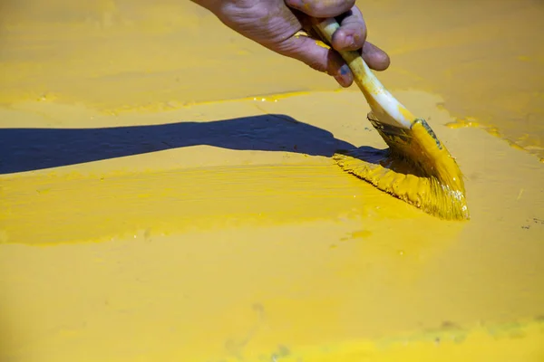 Pintura en amarillo. Trabajar con un pincel. — Foto de Stock