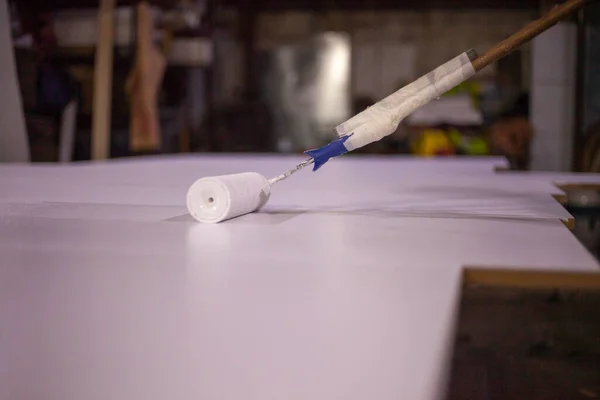 Pintar el tablero con pintura blanca. Trabajos de rodillos —  Fotos de Stock