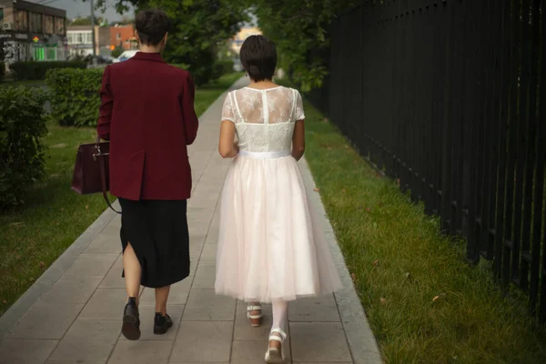 İki kız sokakta farklı kıyafetlerle yürüyorlar.. — Stok fotoğraf