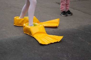 Ayaklarında ördek çizmeleri var. Komik koşu ayakkabıları. 