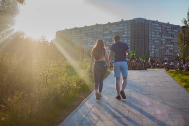Sevgi dolu bir çift gün batımında parkta yürüyor..