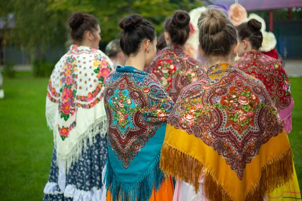 Mensen sjaals op de schouders van de meisjes. Russische traditionele jurk voor vrouwen. — Stockfoto