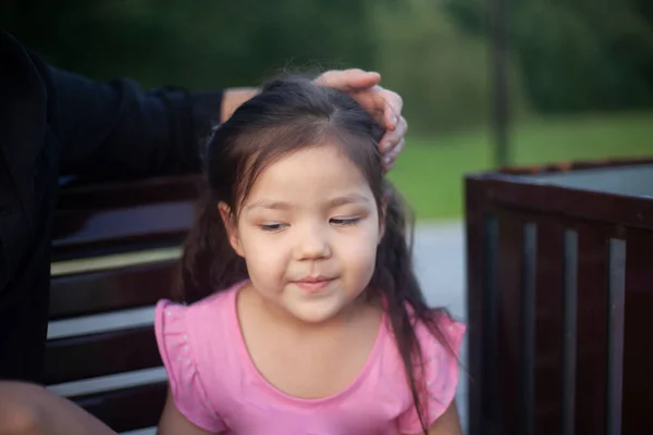 The child wants to sleep. The girl closed her eyes. Portrait of an Asian child. Child for a walk. Girl on the street.