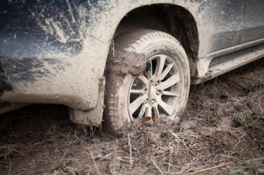 Arabanın tekerlekleri çamura saplanmış. Off-road sürücüsü.