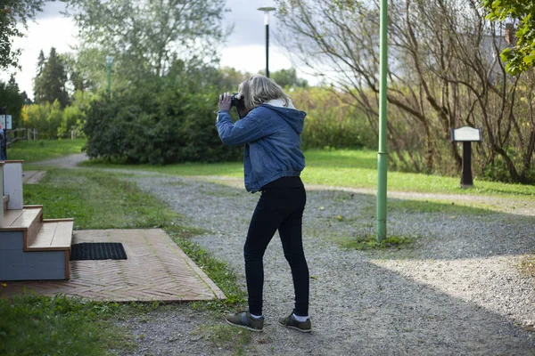 Flickan fotograferar förorten. Fotografen filmar området för dödsboet. — Stockfoto