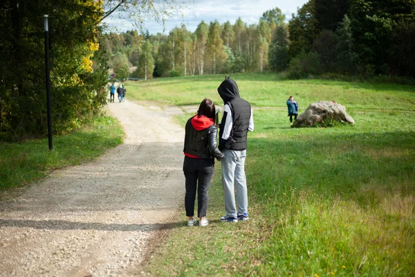 Gå i parken. En man och en kvinna står på vägen i varm höst — Stockfoto