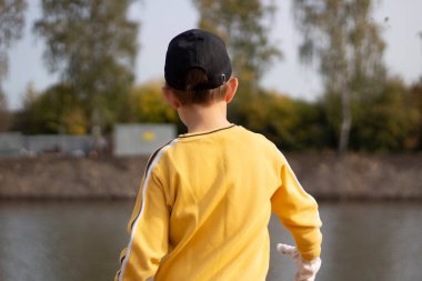 Sarı ceketli çocuk. Gün ışığında bir çocuğu arkadan vurmak.. 