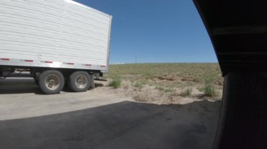 Yarı kamyonlu römork geri geri geri gidip frenleri ayarlıyor. Kamera açısı aracın solundan karavanın arkasına ve arkasına doğru. 3 Haziran 2018 'de Twin Falls, Idaho' da çekildi..