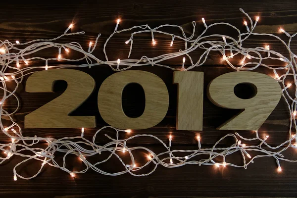 Garland en iyi manzaralı koyu ahşap arka plan üzerinde yeni yıl 2019