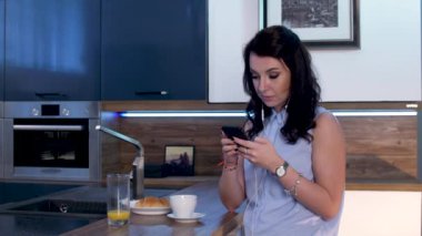 Genç bir kadın kahve içer ve telefonda 11 sms Gönderen