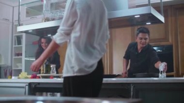 Genç erkekler ve kızlar arkadaşça bir parti için lezzetli yemekler ve kokteyller hazırlayın.
