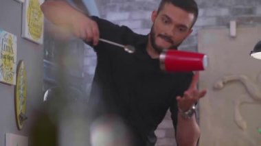 Genç bir barmen arkadaşlara güzel ve lezzetli bir kokteyl hazırlıyor.