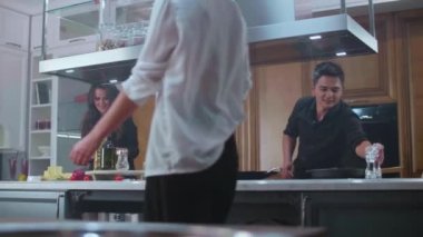 Genç erkekler ve kızlar arkadaşça bir parti için lezzetli yemekler ve kokteyller hazırlayın.