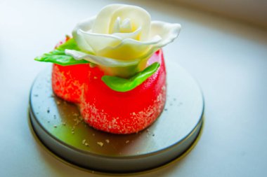 Beyaz kırmızı marmelat kalbi yeşil yaprakları ile gül, severler ve düğünler için tatlılar.