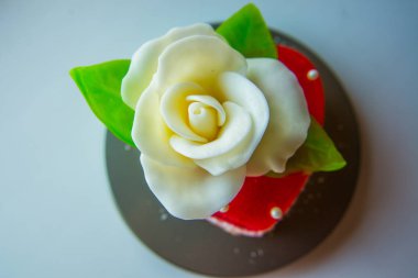 Beyaz kırmızı marmelat kalbi yeşil yaprakları ile gül, severler ve düğünler için tatlılar.