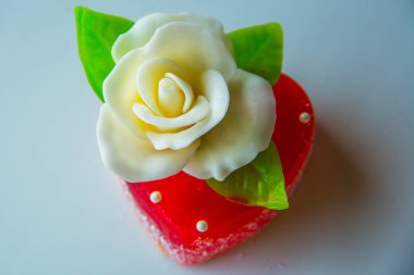 Beyaz kırmızı marmelat kalbi yeşil yaprakları ile gül, severler ve düğünler için tatlılar.