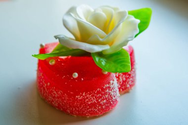Beyaz kırmızı marmelat kalbi yeşil yaprakları ile gül, severler ve düğünler için tatlılar.