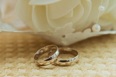 İki güzel altın yüzük gelin ve damat bir buket çiçek yalan.