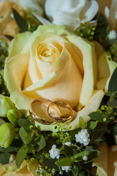 两个美丽的黄金订婚戒指的新娘和新郎在一个大的黄色玫瑰花束 — 图库照片
