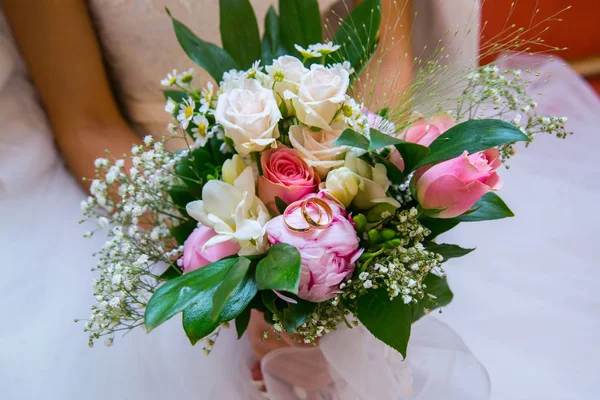 Dos anillos de oro están en el ramo de novias. Hermosas flores en el día de su boda — Foto de Stock