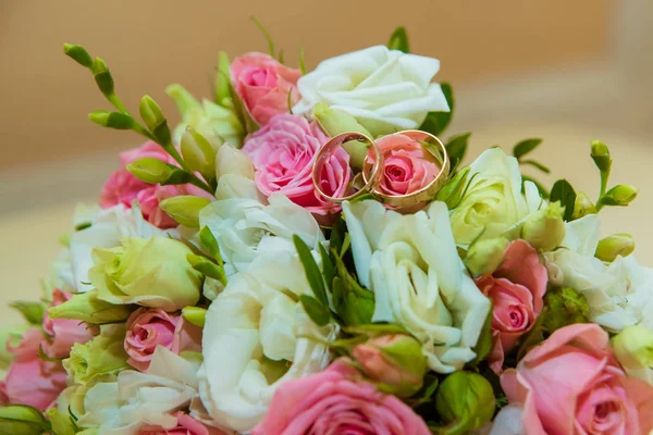 Guld vigselring. Romantiska två diamond förlovningsringar är på brudar bukett av rosa rosor och vita blommor — Stockfoto