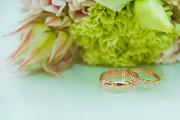 结婚戒指两个金戒指的新娘和新郎的钻石是在白色的表面 — 图库照片
