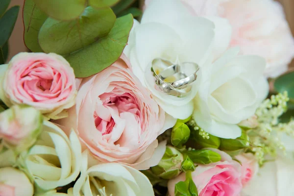 Beyaz altın alyans. Gelin ve damat ve pembe güller ve beyaz çiçek bir buket iki platin yüzük — Stok fotoğraf