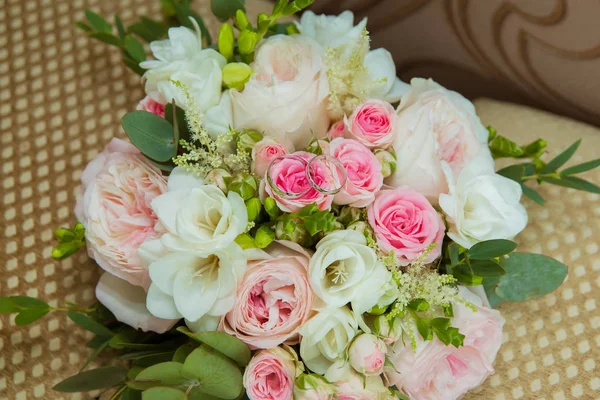 Sortija de boda en oro blanco. Dos anillos de platino de la novia y el novio y un ramo de rosas rosadas y flores blancas — Foto de Stock